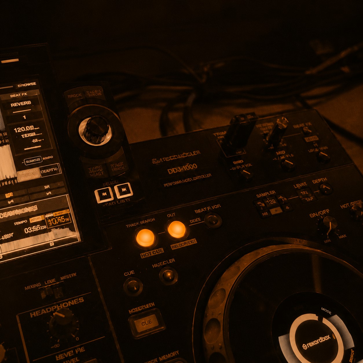 DJ behind the decks, amber stage lights